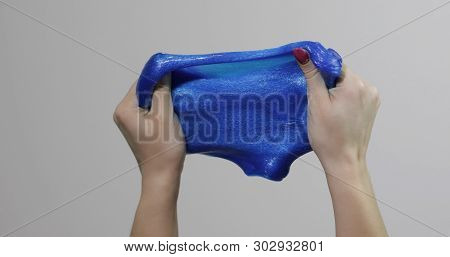 Woman Hands Playing With Oddly Satisfying Blue Slime Sticky Gooey Substance On White Background. Sup