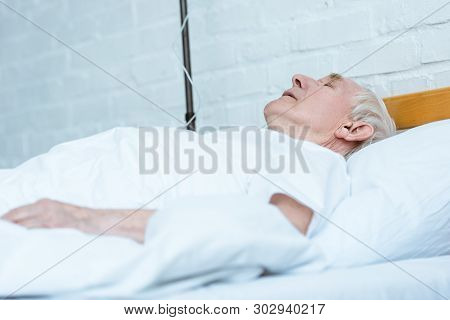 Senior Man In Coma Lying On Bed In Clinic