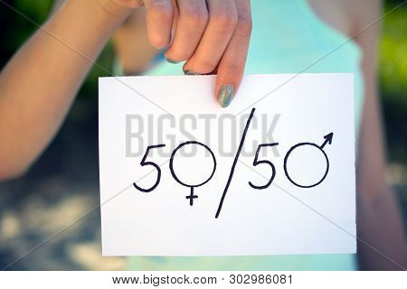 Gender Differences Concept, A Piece Of Paper With A Female And A Male Symbol In A Woman's Hand