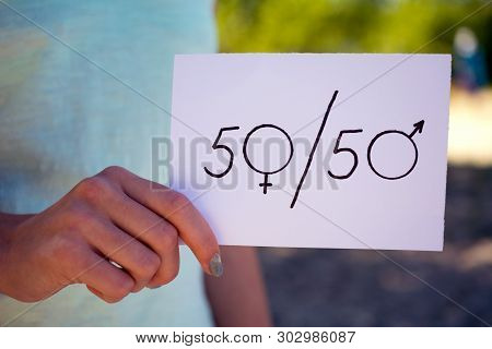 Gender Equality Concept, A Piece Of Paper With A Female And A Male Symbol In A Woman's Hand