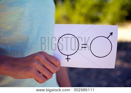 Gender Equality Concept, A Piece Of Paper With A Female And A Male Symbol In A Woman's Hand