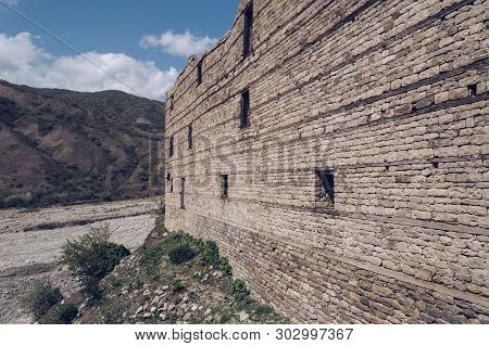 Ruins Of Big Stone Mansion In The Mountain Village Lahchi With Withered River Bed On Background