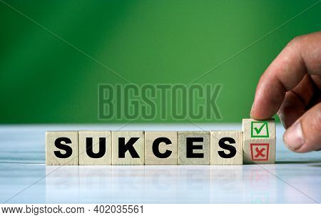 The Hand Turns The Wooden Cube And Changes The Polish Word Sukces (english Success)  With Green Posi