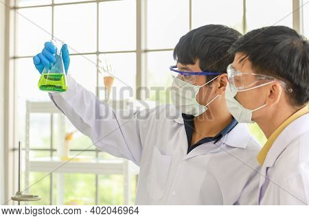 Science And Healthcare Concept. Two Docter Scientists Are Experimenting With Chemicals With Beakers 