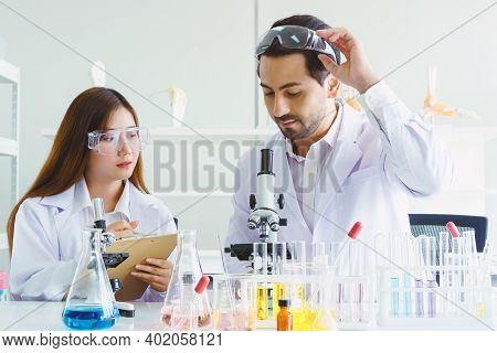 Doctor And Microbiologist With Vacuum Tubes For Samples With Covid 19 Infection Atypical Pneumonia V