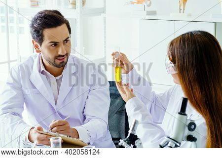 Doctor And Microbiologist With Vacuum Tubes For Samples With Covid 19 Infection Atypical Pneumonia V