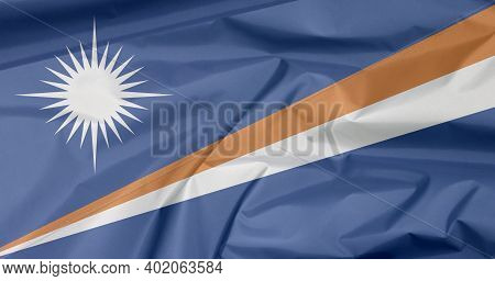 Fabric Flag Of Marshall Islands. Crease Of Marshall Flag Background, A Blue Field With Two Diagonal 