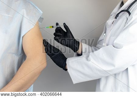 Infectious Disease Doctor Gives The Patient A Medical Vaccination In The Shoulder. Immunization Agai