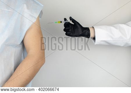 Infectious Disease Doctor Gives The Patient A Medical Vaccination In The Shoulder. Immunization Agai