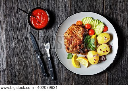 Roasted Pork Karbonade, Pork Cutlets With Boiled Potato And Sliced Cucumber And Lemon On A Plate On 