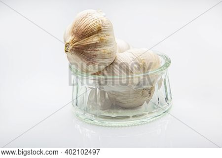 Two Garlic  Bulb In A Glass Pot Against A White Background