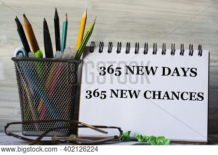 365 New Days 365 New Chances - Words In A Notebook With Glasses And A Jar Of Pencils. Education Conc