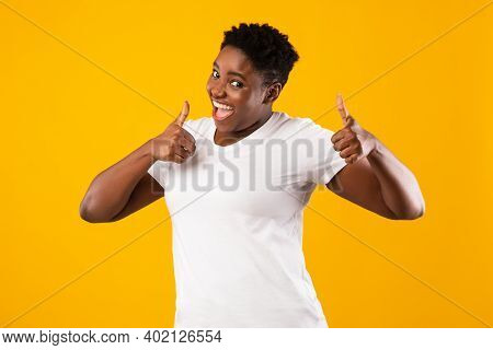 Funny Plus-size Black Lady Gesturing Thumbs Up With Both Hands Smiling To Camera And Approving Somet