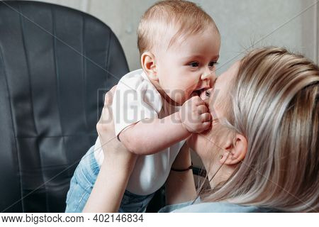 Baby Bites Nose Of Mother. Concept Of Loving Mother And Child. Mother Playing With Baby.