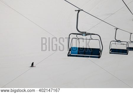 Ski Chair Lift At The Ski Resort. Skier Rolls Down The Mountain View From The Funicular