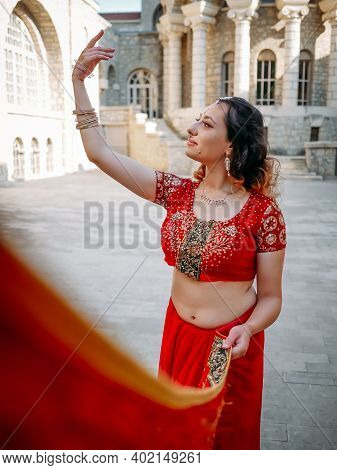 Indian Woman Dance On Streets Of Ancient Architecture City Of India Dressed In Red Sari, Decorated W