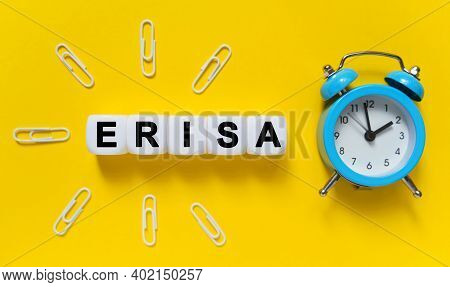 Finance And Economics Concept. On A Yellow Background, A Blue Alarm Clock, Paper Clips And White Cub