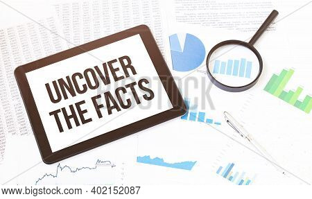 Cropped Image Of Businessman Examining Graph On Digital Tablet With Magnifying Glass At Office Desk.