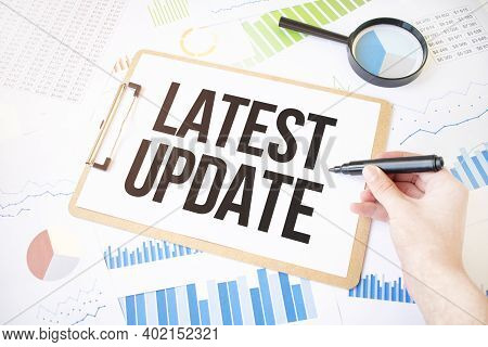 Text Latest Update On White Paper Sheet And Marker On Businessman Hand On The Diagram. Business Conc