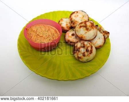 Paddu Or Kuzhi Paniyaram And Coconut Chutney In A Green Plate Isolated On White Background. Indian D
