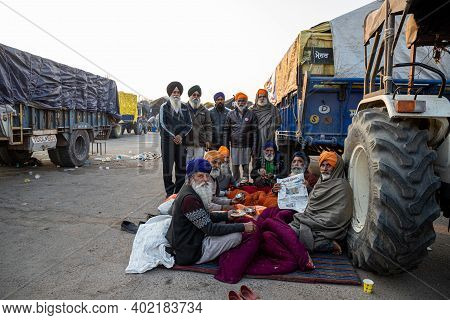 New Delhi, India - December 2020:
Portrait Of A Group Of Farmer Reading News Paper During The Protes