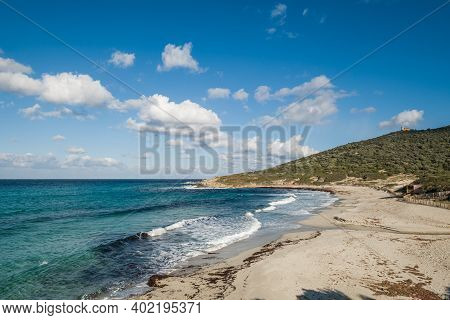 Waves Washing Onto A Deserted Bodri Beach In The Balagne Region Of Corsica Under A Blue Sky
