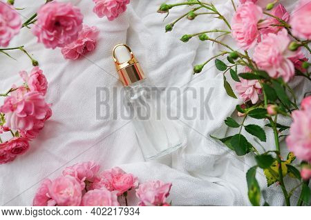 Essential Cosmetic Oil With Roses On White Background. Selective Focus.