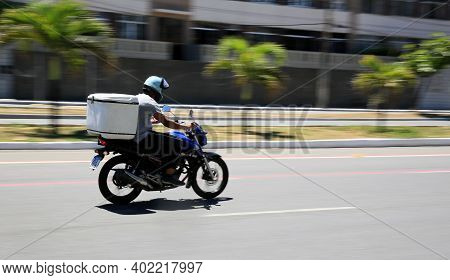 Motorcyclist Is Seen Walking Down The Street
