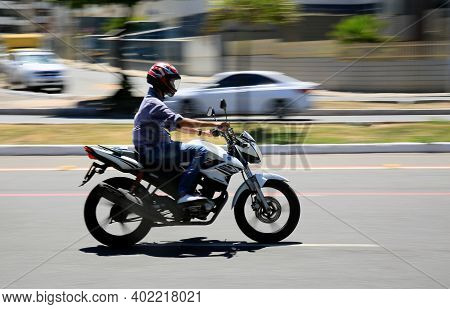 Motorcyclist Is Seen Walking Down The Street