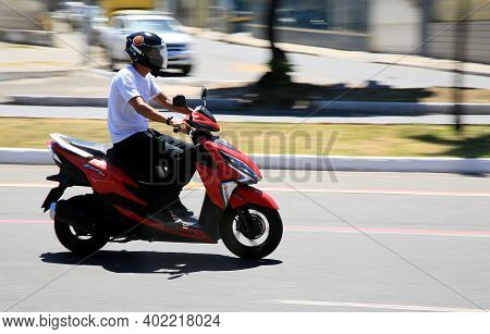 Motorcyclist Is Seen Walking Down The Street