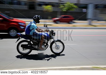 Motorcyclist Is Seen Walking Down The Street