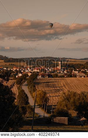Photo Of Landscape With City Of Telc With Hot Air Balloon Above The City.