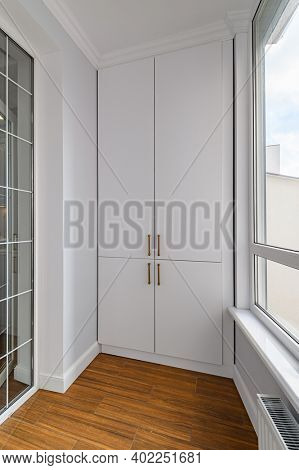 Empty heated penthouse or lodge living room with wood laminate floor and full height windows and built in closet