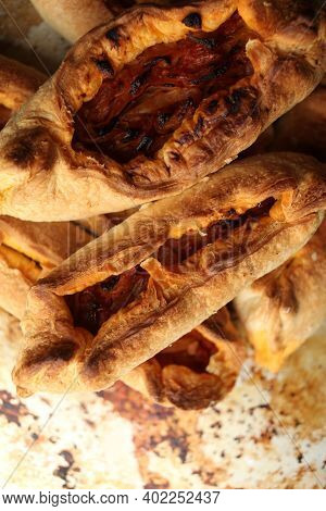 Twisted Pastry Stuffed With Cabbage On The Table. Russian Open Pirozhki, Baked Patties Stuffed With 