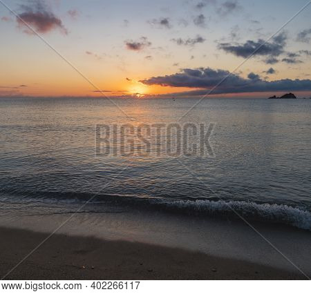 Sunrise With The Red Orange Sun Raising Up From The Sea With Dark Clouds At Beach Spiaggia Di Santa 