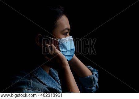 Asian Woman Wearing Protective Mask Isolated Over Background. Low Key.