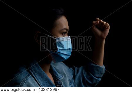 Asian Woman Wearing Protective Mask Isolated Over Background. Low Key.