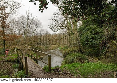 Footbridge Over A Bend In The River Itchen In The Village Of Itchen Stoke, Hampshire On A Cloudy Aut