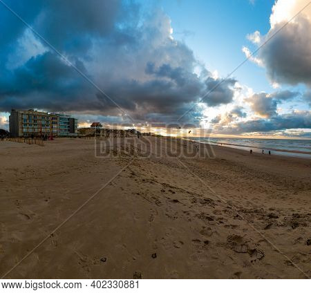 View On An Empty Beach Of Sint-idesbald In Koksijde At De Panne At Sunset With A Glowing Cloudy Sky 
