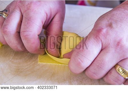 Italian Housewife With Traditional Manual Sheeter Rolls Egg Pasta, The Color Of The Sun Of Italy, Ma