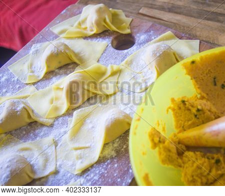 Italian Housewife With Traditional Manual Sheeter Rolls Egg Pasta, The Color Of The Sun Of Italy, Ma