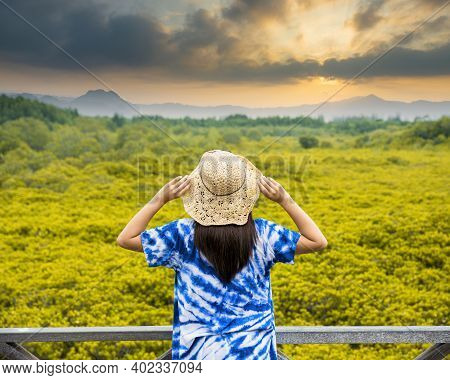 Asian Traveler Woman Holding The Hat And Standing On Wooden Bridge For Travel At Tung Prong Thong Fo