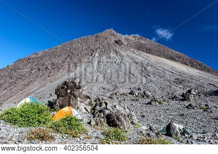 Camping In Front Of Merapi Volcano Lava Dome. Tents On The Slope Of Merapi Mountain, Java Island, In