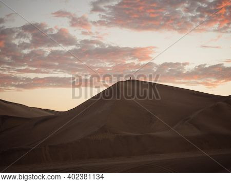 Aerial Postcard Panorama Sunset View Of Isolated Lonely Single Man Person On Dry Sand Dune Desert Of