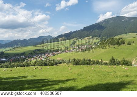 View On Village Liptovska Luzna At The Foothills Of Low Tatras Mountains With Lush Green Meadow, For