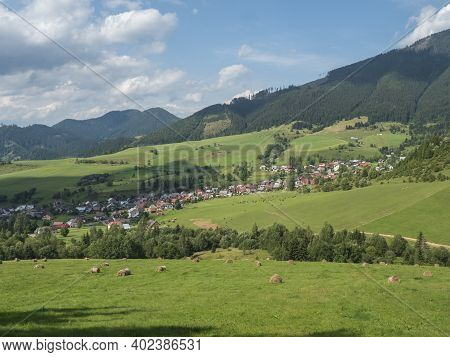 View On Village Liptovska Luzna At The Foothills Of Low Tatras Mountains With Lush Green Meadow, For