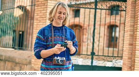 Young scandinavian tourist man smiling happy using smartphone at the city.
