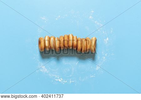 American Doughnuts, Aligned In A Row,  Isolated On Blue Background. Top View With Yeast-raised Donut