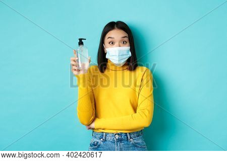 Covid-19, Social Distancing And Pandemic Concept. Cheerful Asian Woman Showing Hand Sanitizer, Recom
