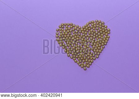 Gold Pearl Sprinkles Arranged In A Heart Shape On A Pink Rustic Background. Valentines Day, Greeting
